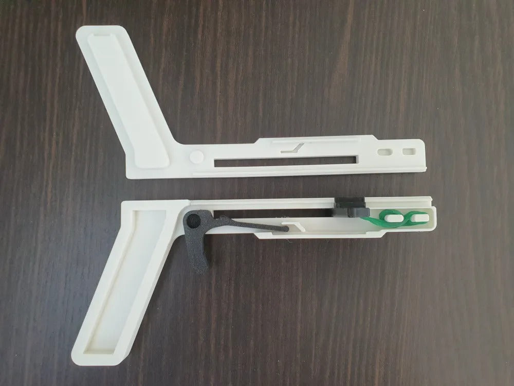 White plastic tool with a green component on a wooden surface